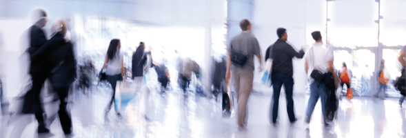 Verschwommenes Bild mit Menschen in einer Halle.
